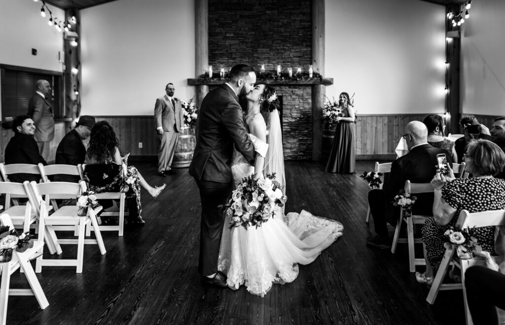 Bride and groom stop for a kiss in the middle of the isle after I do's said.
