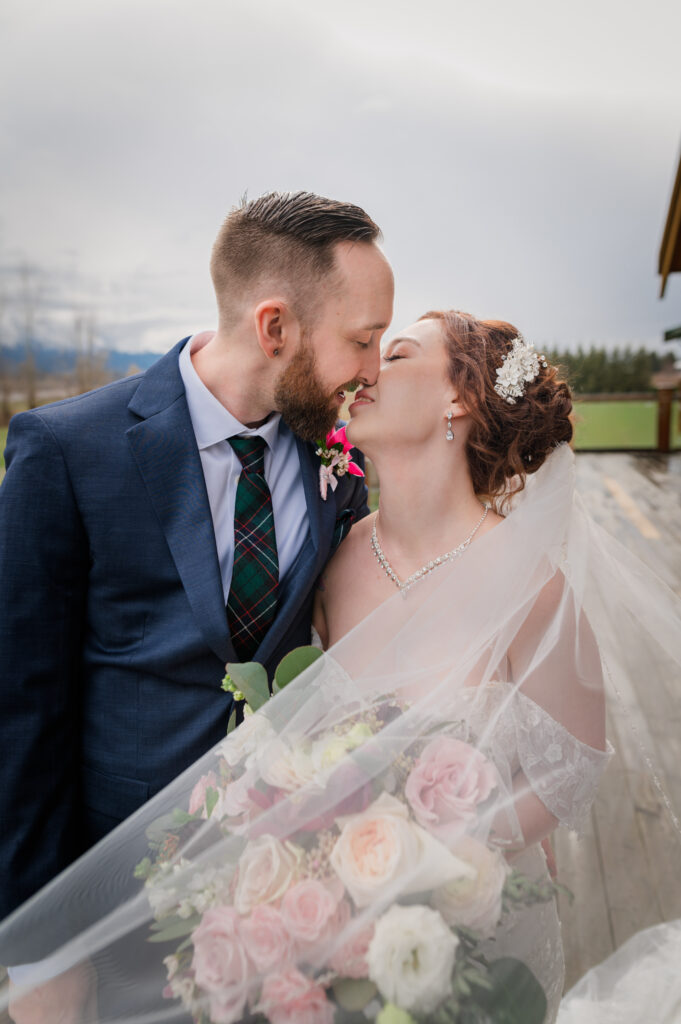 Bride and groom kissing each other on their wedding day.