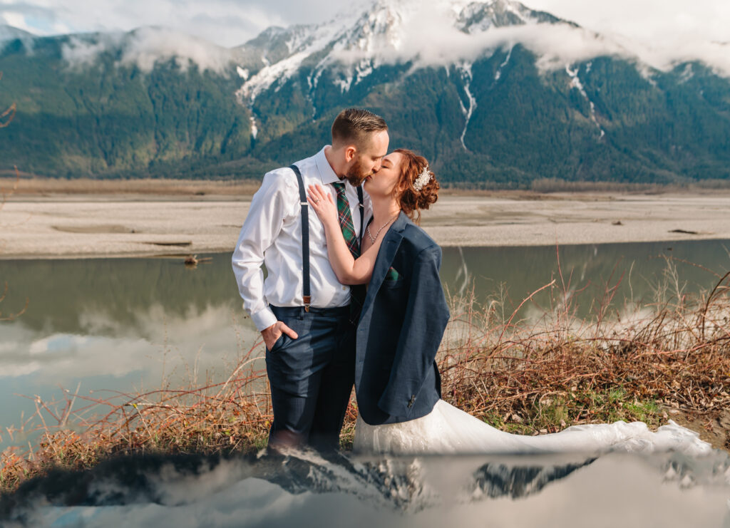 Couple kiss on their wedding day and beautiful Fraser River mountain in the back round. 