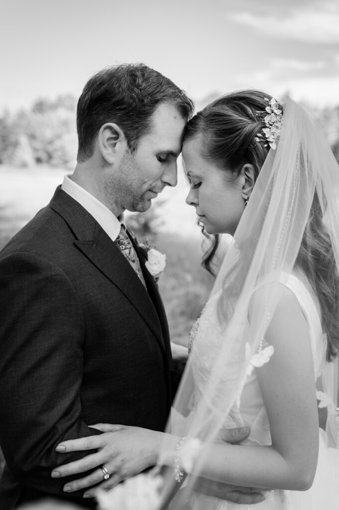 black-and-white-wedding-photo-bride-and-room-foreheads-touching.