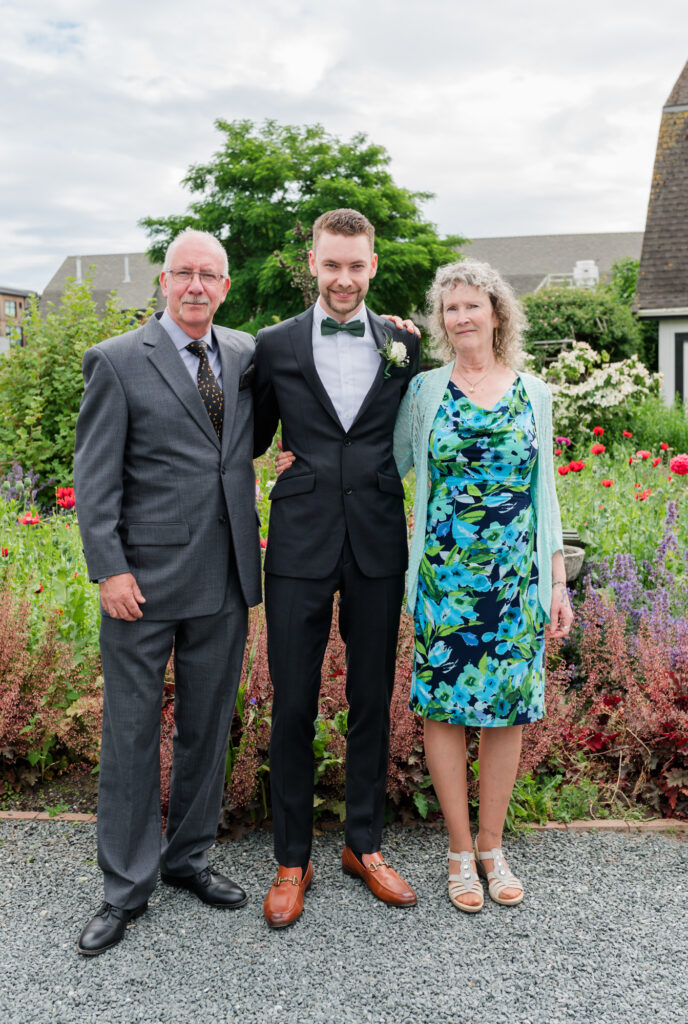 Groom and his parents on his wedding day a flower garden at Tsawwassen Southlands Red Barn. 