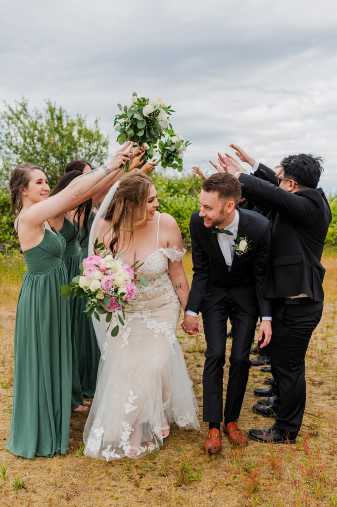 Bride and groom looking at each other having fun with wedding photos with the group.