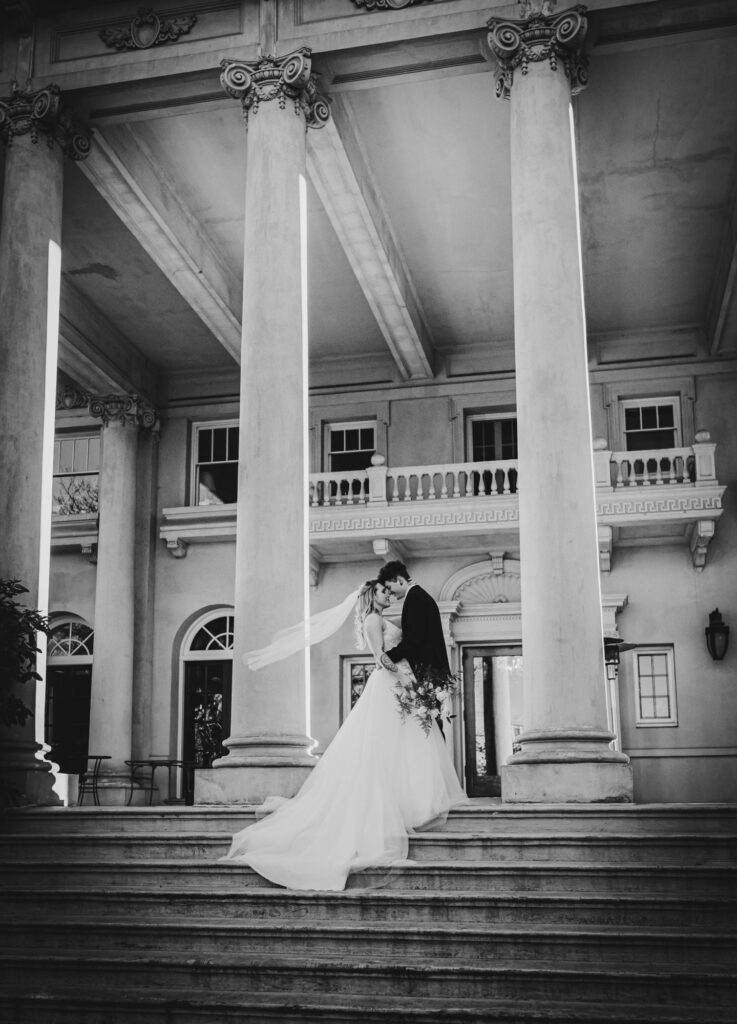 Romantic pose of newlyweds on the back steps at Hycroft Manor.