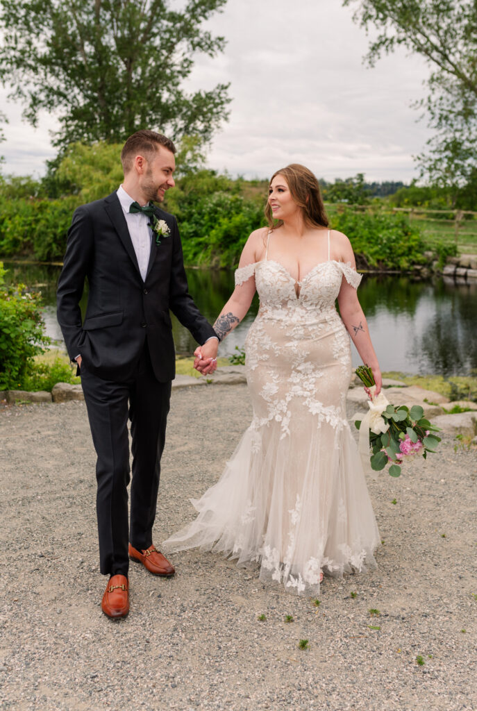 Bride and groom looking at each other and holding one hand.
